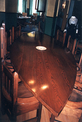 Formal dining room table. It is believed that Tim Riordan designed the table himself -- its shape offered ease of conversation with guests. The dining room itself is oval to complement the table.